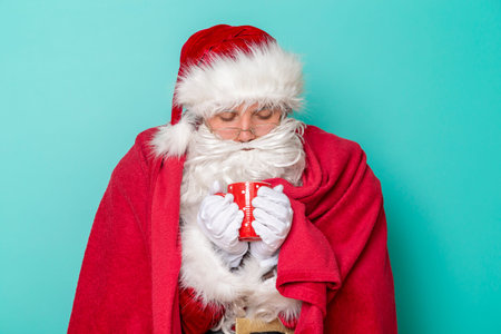 Santa Claus sick for winter holiday season, having a flu and fever, covered with soft red blanket,...