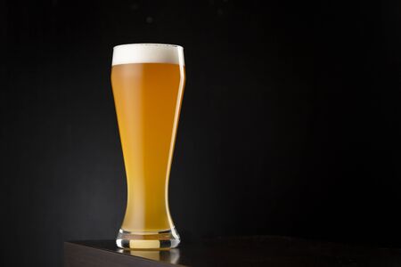 Glass of cold unfiltered wheat beer on a bar counterの写真素材