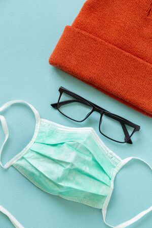 Surgical face protection mask glasses and a hat isolated on green color background. Medical face protection mask as part of protection gear against coronavirus infectionの写真素材