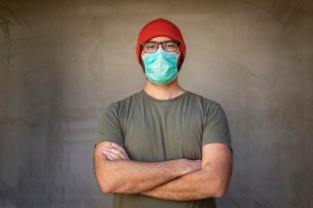 Portrait of man wearing medical face protection mask; air pollution or allergies protection,...