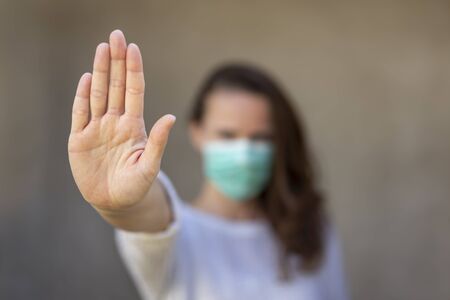 Woman wearing medical face protection mask; air pollution or allergies protection, coronavirus, bacterial and viral respiratory infections prevention and social distancing conceptの写真素材