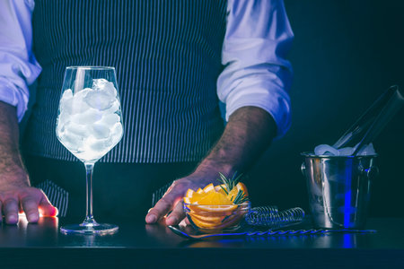 Bartender standing behind a bar counter, preparing cocktails while working in a nightclub