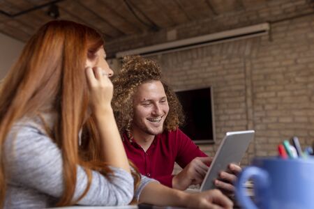 Two software developers working on a new project in a software developing company office; freelancers working in modern co-working spaceの写真素材