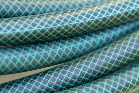 Close up of a plastic coiled blue and green garden water hoseの写真素材