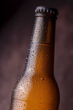 Detail of cold, wet beer bottle with dew and condensate water droplets on the surface of the glassの写真素材