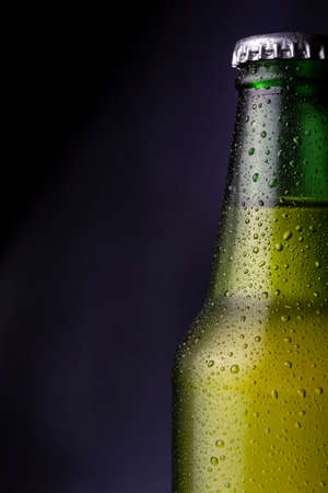 Detail of cold, wet beer bottle with dew and condensate water droplets on the surface of the glassの写真素材