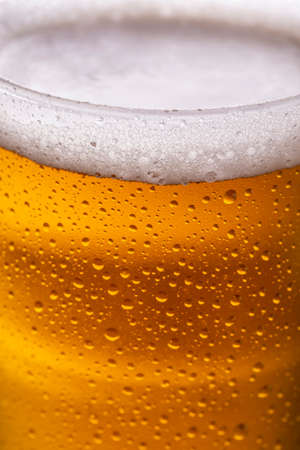High angle view of glass of cold beer with dew and condensate water droplets on the surface of the glassの写真素材