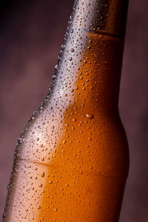 Detail of cold, wet beer bottle with dew and condensate water droplets on the surface of the glassの写真素材