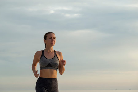 Active woman in sportswear jogging early in the morning