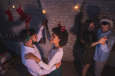 High angle view of two beautiful young couples dancing waltz at New Years Eve party after the midnight countdownの写真素材