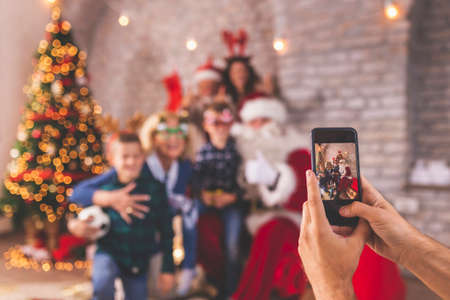 Happy family gathered at home for Christmas, having fun while opening presents with Santa Claus, children palying with their new toysの写真素材