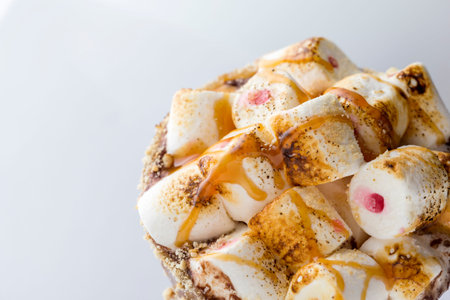 High angle view of a glass of hot chocolate with marshmallows, caramel topping and shocolate chip...
