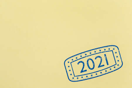 Ink stamping sheet of orange paper; close up of ink stamp with numbers 2021 representing the upcoming New Year on page of orange paper with copy spaceの写真素材