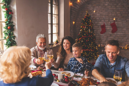 Beautiful happy family gathered around the table, having Christmas dinner, enjoying their time...