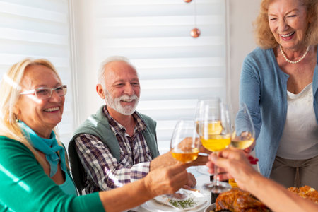 Group of senior friends having fun while celebrating Thanksgiving together at home over traditional...