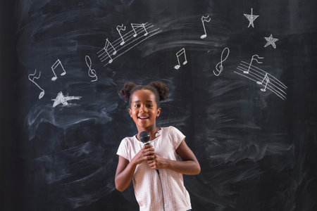 Beautiful mixed race elementary school girl sitting in chair in front of a chalkboard pensive and serious, thinking, with clouds drawn above her headの写真素材