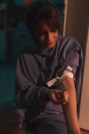 Junike shooting up with heroin; female drug addict injecting herself with heroin dose intravenously;...