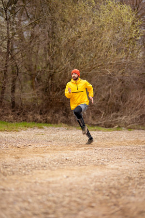 Athletic man jogging by the river on a cloudy autumn day