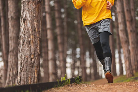 Detail of a man working out outdoors on a cloudy autumn day, walking down the jogging track