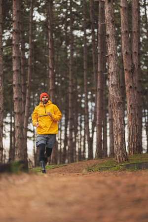 Detail of a man working out outdoors on a cloudy autumn day, walking down the jogging trackの写真素材