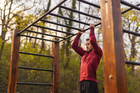 Athletic young man carrying gym bag, drinking water after an intense outdoor workout in a street...