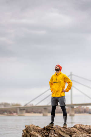 Active man jogging in the park in the morning on a cloudy autumn day, taking a break and relaxingの写真素材