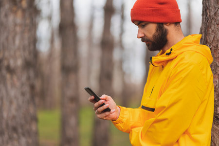 Active man jogging in the park in the morning on a cloudy autumn day, taking a break and relaxing,...