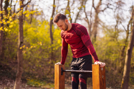 Man working out outdoors in street workout park, doing crunches