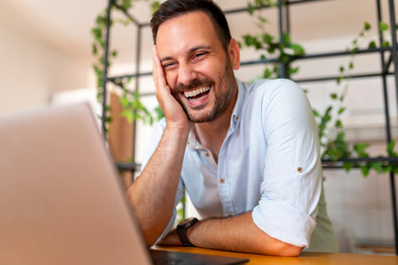 Man having video call using laptop computer while working remotely from homeの写真素材