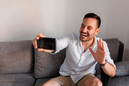 Cheerful man celebrating after winning an online mobile phone app bet; man gambling online