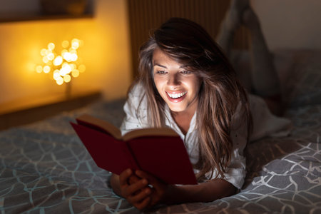 Beautiful woman relaxing at home late at night, sitting in bed having video call using tablet...