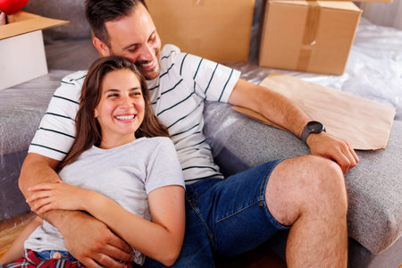 Beautiful young couple in love lying on the floor of their new home and relaxing, taking a break...