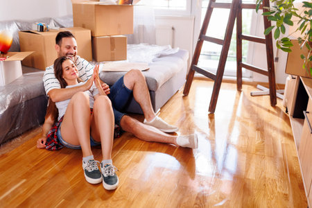 Beautiful young couple in love lying on the floor of their new home and relaxing, taking a break...