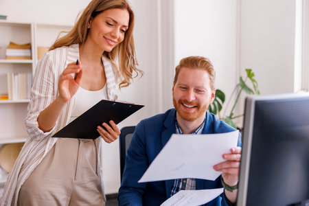 Business colleagues having fun taking a lunch break at the office, eating pizza and drinking coffeeの写真素材