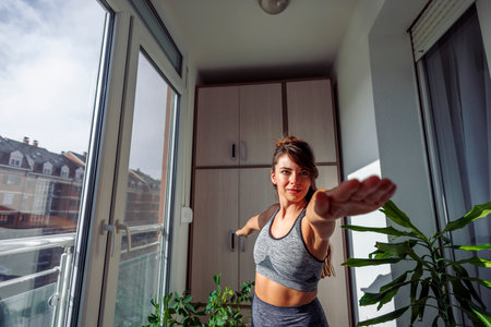 Young woman in sportswear exercising at home in the morning, doing yogaの写真素材