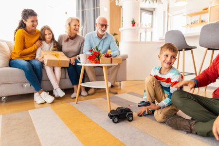 Happy family gathered at home for Christmas day, having fun celebrating Christmas at home, father and son playing with remote controlled car toy child got as Christmas presentの写真素材