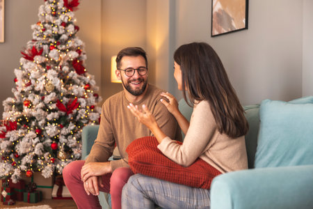 Beautiful happy couple in love having fun spending Christmas day together at homeの写真素材