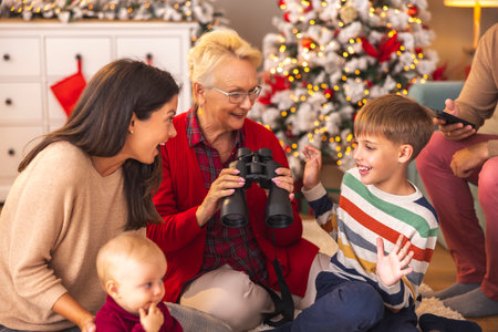 Happy multi-generation family having fun spending Christmas day together at home, mother and grandmother playing with childrenの写真素材