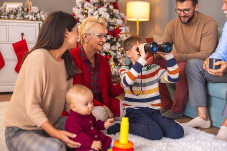 Happy multi-generation family having fun spending Christmas day together at home, children playing with toys they got as presentsの写真素材