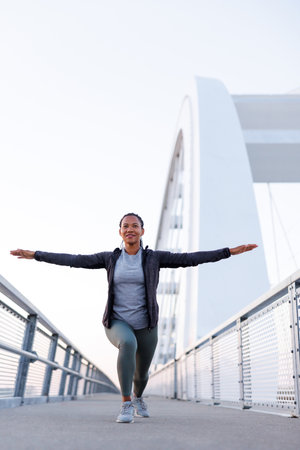 Active woman in sportswear warming up and stretching out before morning jogging or outdoor workout sessionの写真素材