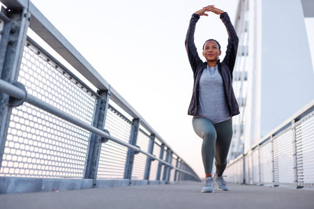 Active woman in sportswear warming up and stretching out before morning jogging or outdoor workout sessionの写真素材