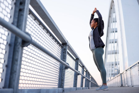 Active woman in sportswear warming up and stretching out before morning jogging or outdoor workout session - healthy lifestyle conceptの写真素材