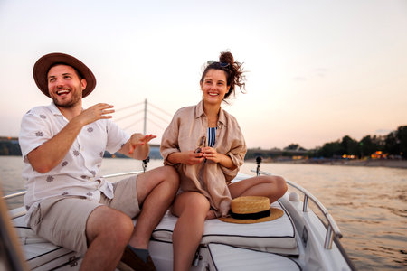 Beauitful young couple in love relaxing and having fun sailing on a boat while on summer vacationの写真素材