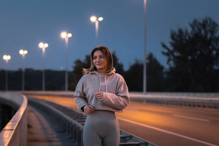 Active young woman in sportswear jogging early in the morning at dawn before suriseの写真素材