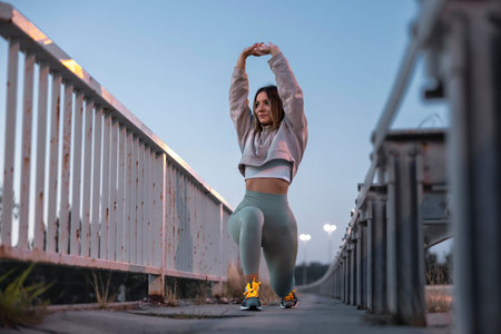 Low angle view of active young woman stretching out before jogging early in the morning