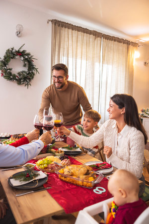 Beautiful happy multi-generation family gathered around the table, having Christmas dinner all together at home, celebrating Christmas and making a toastの写真素材