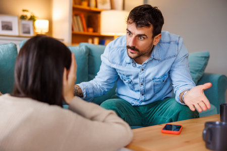 Young couple arguing at home, yelling at each other - marriage divorce or relationship break up conceptの写真素材