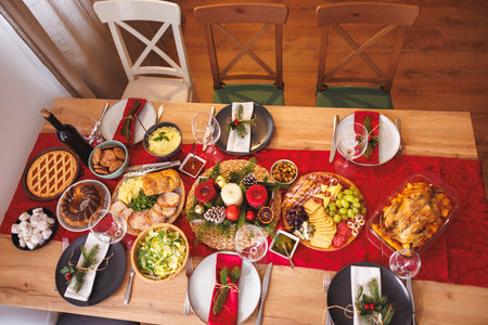 High angle view of beautiful Christmas dinner table setting at cozy home ready for holiday family gatheringの写真素材