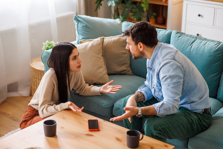 High angle view of young couple arguing at home, yelling at each other - marriage divorce or relationship break up conceptの写真素材