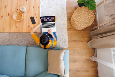 High angle view of woman working remotely from home having an online meeting using laptop computerの写真素材